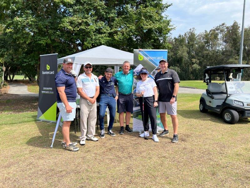 4 golfers with Bartercard employee and Bravehearts CEO at Bartercard tent