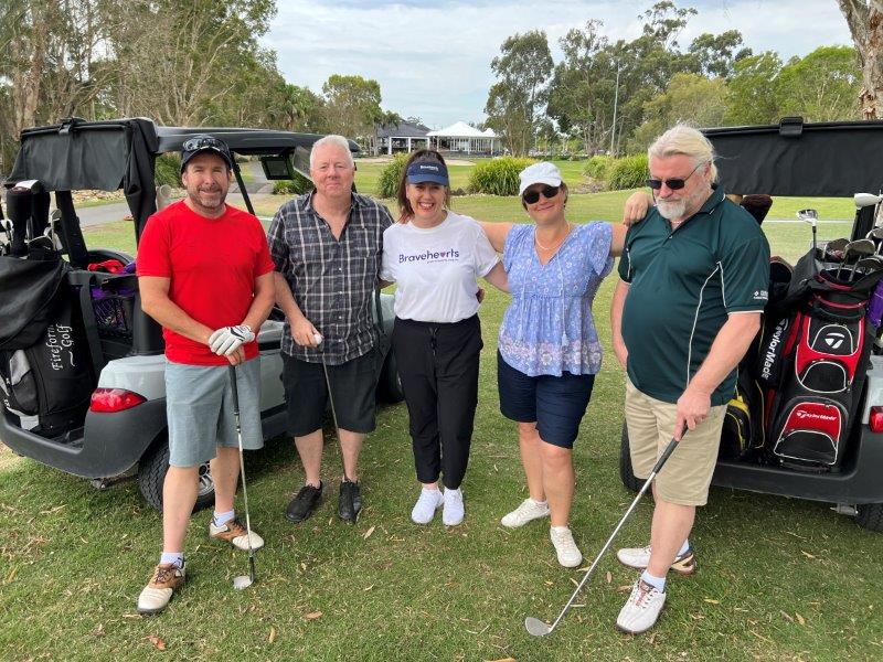 Photo of 4 golfers in front of golf buggies with bravehearts CEO