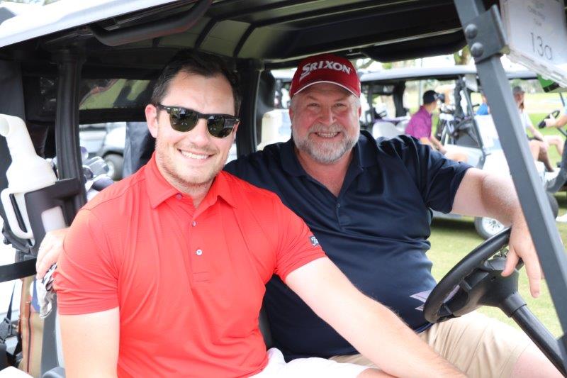 2 male golfers on golf buggy