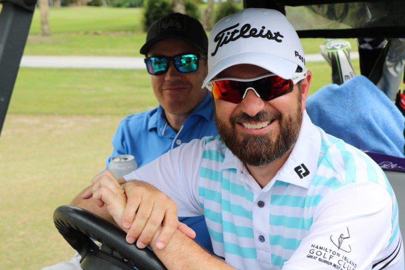 2 male golfers on golf buggy