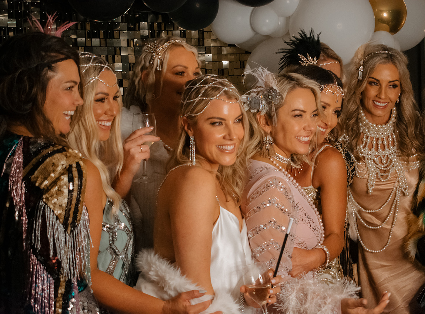 Profile group photo of 8 attractive women in Gatsby themed dresses