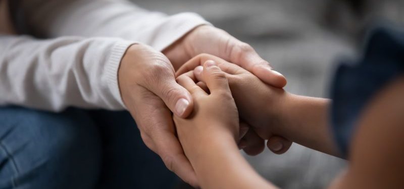 child and parent holding hands